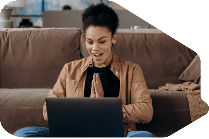 A woman looking surprised looking at her laptop