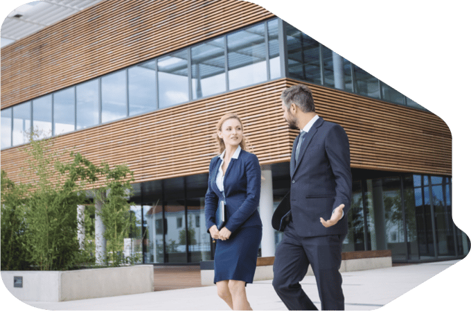 A businessman and woman walking outside of a building